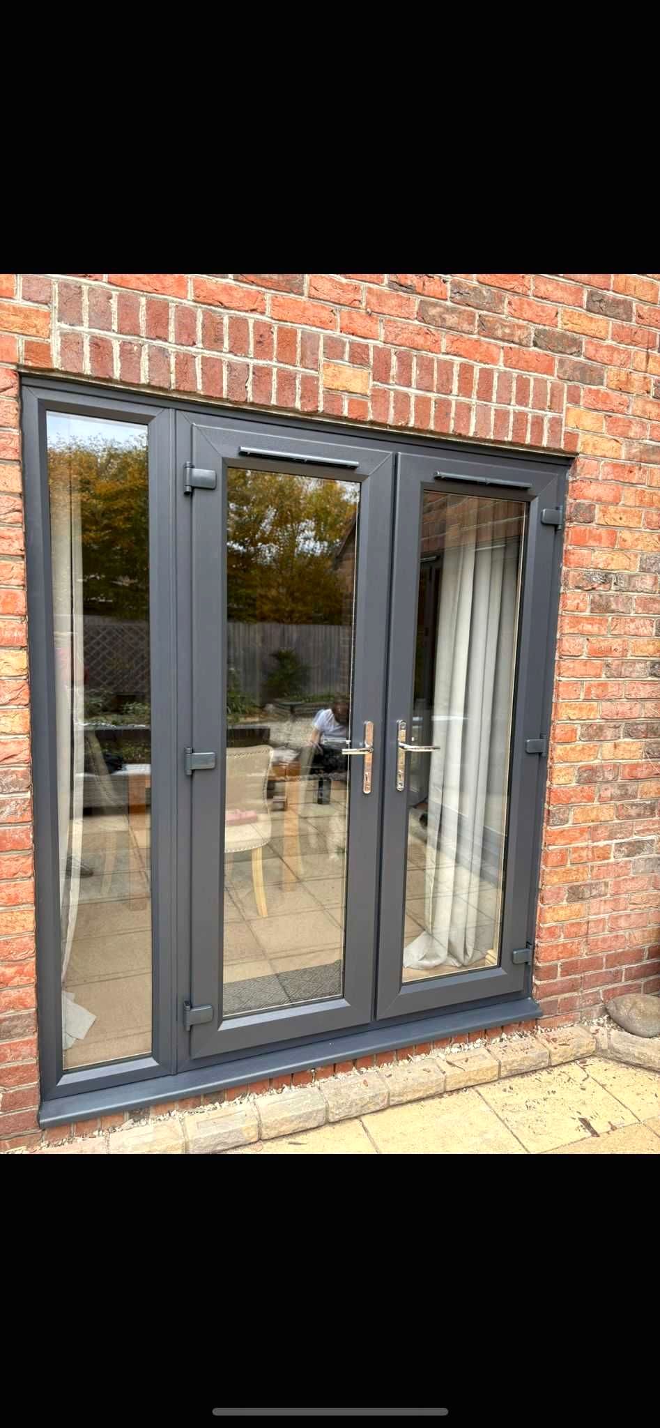 Modern grey french doors installation on brick extension